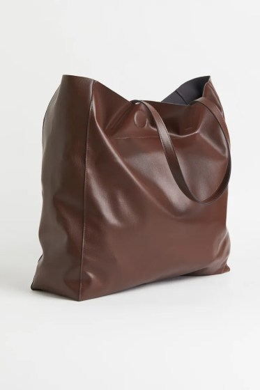 Γυναικεία καφέ τσάντα shopper από υψηλής ποιότητας γυαλιστερό συνθετικό δέρμα. Αυτή η τσάντα shopper είναι μεσαίου μεγέθους και κλείνει με μαγνητικό κούμπωμα. Υπάρχει μια ενιαία μεγάλη θήκη και εσωτερική τσέπη που κλείνει με φερμουάρ. Διαθέτει δύο λαβές 